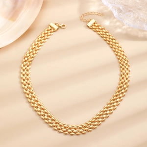 Close-up of triple-layered golden watch-style chain necklace with lobster clasp and extender