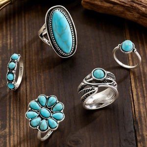 Detail von Silber-Ring-Set mit Türkis-Steinen auf dunklem Holzmaserungshintergrund
