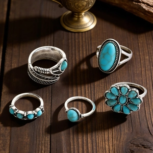 Detailaufnahme von Boho-Türkis-Ringsets auf rustikalem dunklem Holz Hintergrund