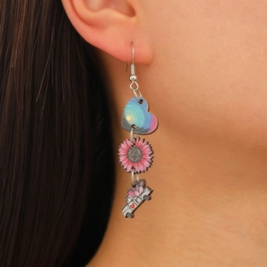 Gros plan de boucles d'oreilles pendantes avec cœur et tasse à café portées par un modèle