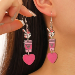 Détail des boucles d'oreilles en bois tasse à café rose et cœur léopard portées