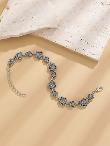 Detail of vintage silver rose link bracelet with adjustable chain on stone background
