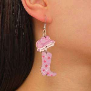 Détail de boucles d'oreilles chapeau et botte de cowboy roses avec étoiles et texte