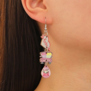 Détail de boucles d'oreilles pendantes avec cœur rose et breloque voiture sur mannequin