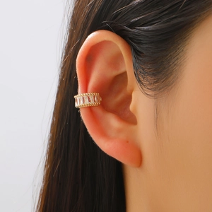 Golden ear cuff with rectangular zircons worn on model's ear without piercing