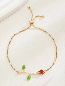 Detailed close-up of a gold rose bracelet featuring a red flower bud and bolo clasp