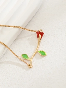 Detail of red enamel rose pendant with green leaves on gold box chain necklace