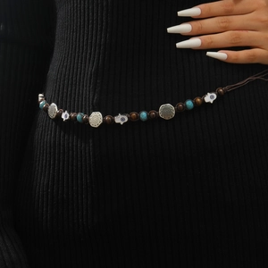 Detail of woven Bohemian waist chain with Hamsa Hand charms and blue Evil Eye beads