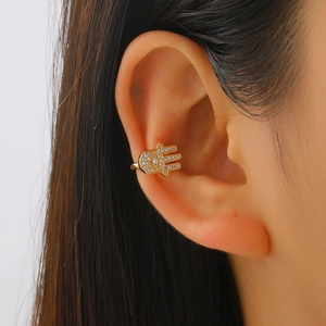 Gold Hamsa Hand ear cuff with pavé crystals shown on the upper cartilage