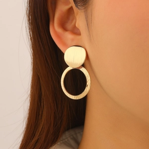 Detail of elegant gold double-circle earrings with brushed texture on model ear