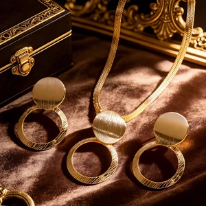 Detail of matte gold jewelry set with brushed texture and snake chain on velvet