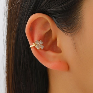 Golden four-leaf clover ear cuff with micro-pave cubic zirconia on a female model