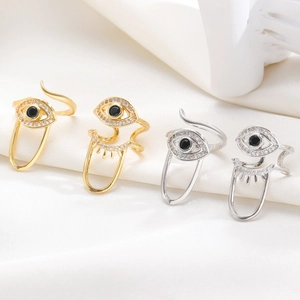 Macro view of gold and silver plated evil eye rings with zircon stones on silk