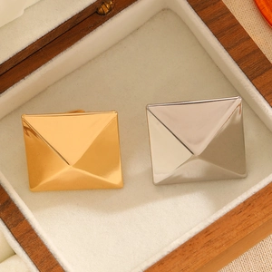 Exaggerated geometric square pyramid rings in gold and silver finish inside a jewelry box