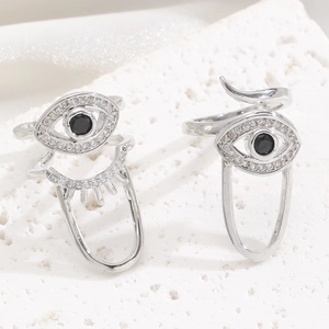 Macro shot of silver evil eye fingernail rings with white zircons and black center stones
