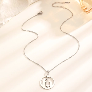 Close-up of silver stainless steel religious pendant featuring the Nativity scene cutout
