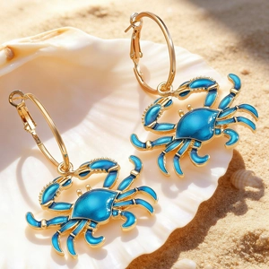 Macro detail of gold lobster crab earrings with blue enamel inside a white sea shell