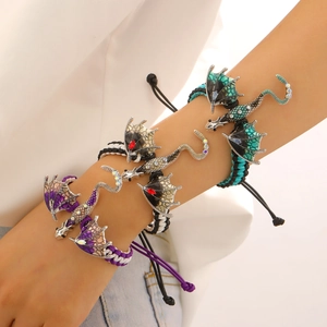 Close-up of woven dragon bracelet with purple enamel scales and sparkling crystals
