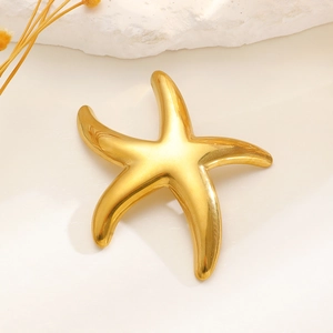 Detailed view of a golden starfish brooch with a polished metallic finish on white stones