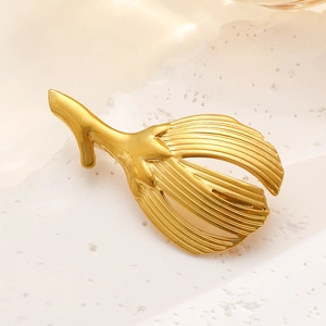 Detailed macro view of golden leaf brooch with fine vertical textured metal patterns