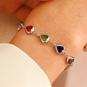 Bracelet pierres précieuses en forme de cœur avec chaîne argentée porté au poignet