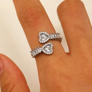 Detailed view of silver heart ring with sparkling zircons worn on a finger