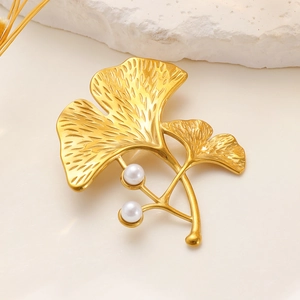 Detail of golden ginkgo leaf brooch with fine vein textures and white pearls decoration