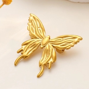 Detailed macro view of a golden butterfly brooch with matte finish and delicate textures