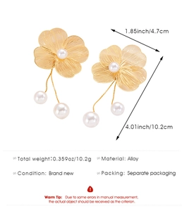 Detailed view of elegant gold alloy floral drop earrings with white pearls and long chains