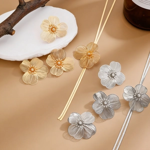 Detail macro shot of luxurious metallic flower earrings with textured golden petals