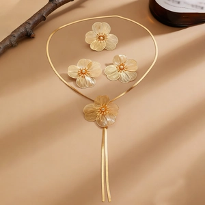 Detailed close-up of golden floral necklace and earrings with textured radial petals