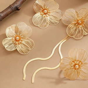Detail of French vintage gold floral earrings and necklace with sleek snake chains