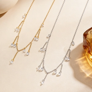 Detail van gouden en zilveren kwastjeskettingen met heldere zirkoon hangers op tafel