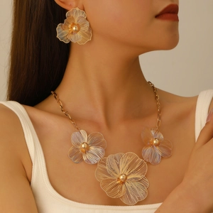Close-up of elegant gold woven flower necklace and earrings set worn by a model