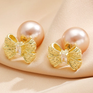 French vintage bow earrings with champagne pearls and zircon on silk background