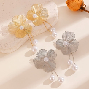 Detailed view of elegant gold and silver floral tassel earrings with white pearls