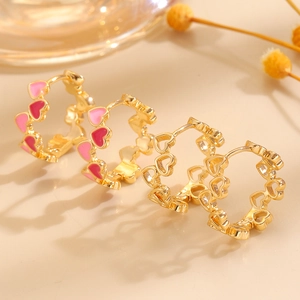 Nahaufnahme von rosa und roten Herzohrringen mit goldenen Herzanhängern