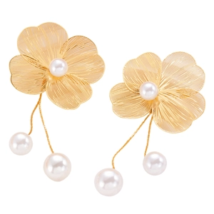 Detail of floral gold pearl earrings with brushed texture petals and hanging white pearls