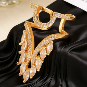 Macro shot of gold-plated nail ring with horse-eye zircon wings on black silk