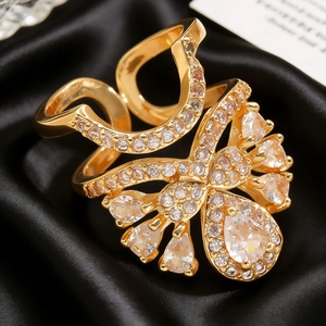 Close-up of gold plated copper nail ring with clear cubic zirconia on black silk