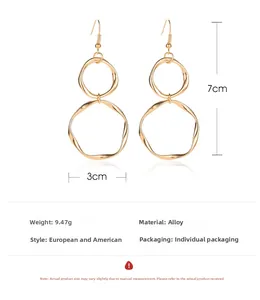 Detail view of gold alloy heart earrings with 7cm length and geometric drop design