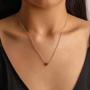 Collier minimaliste avec pendentif cœur doré pour femme porté sur le cou au quotidien