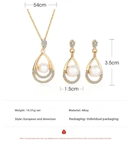Macro detail of gold teardrop necklace and earrings set with white pearls and zircons
