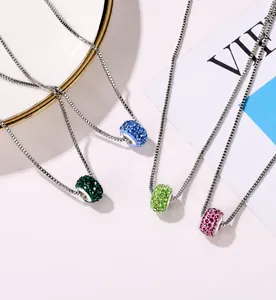 Detailed macro view of colorful Shamballa crystal pavé pendants on silver box chains