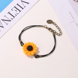 Detail of sunflower bracelet with black braided cord and bronze lobster clasp closure