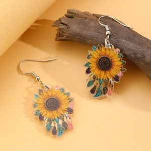 Detail of yellow sunflower earrings with silver hooks on natural wood background