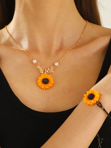Detail of sunflower pendant necklace with pearls and matching black woven cord bracelet