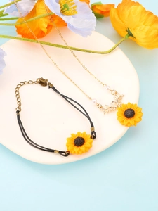 Detailed close-up of a sunflower pendant necklace and matching black woven cord bracelet set