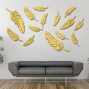 Détail de stickers muraux miroirs 3D plumes dorées sur un mur de salon moderne