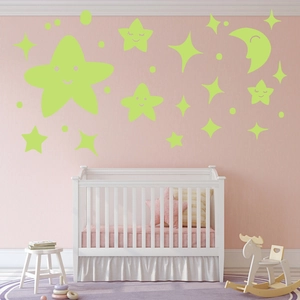Detailed view of glowing green star and moon wall stickers in a cozy nursery room setting